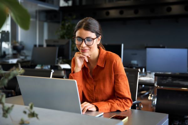 A woman smiling down at her computer